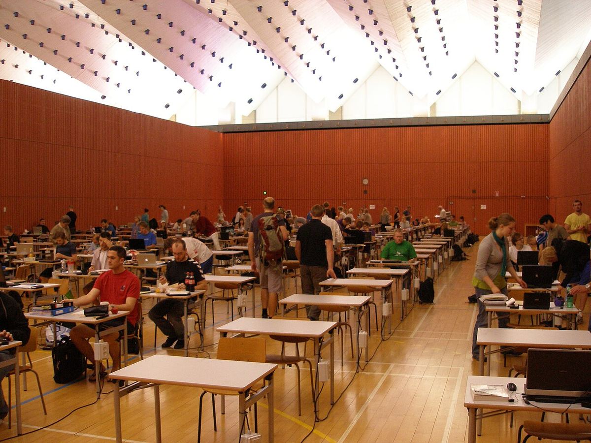 Students sit an exam in a university hall.